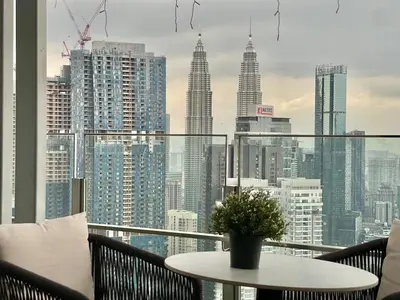 a balcony with a table and a view of a city at 2min walk to TRX,KLCC view Gaming 2pax swimming pool in Kuala Lumpur