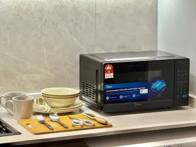 a microwave sitting on a counter with a cutting board at 2min walk to TRX,KLCC view Gaming 2pax swimming pool in Kuala Lumpur