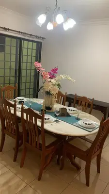 a dining room table with a vase of flowers on it at Cozy Private Room in Taman Desa with Shared Bathroom in Kuala Lumpur