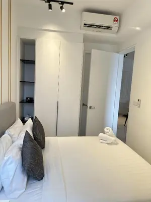 a bedroom with a large white bed with black pillows at Axon Suites near at Pavilion with Rooftop Panoramic City View in Kuala Lumpur