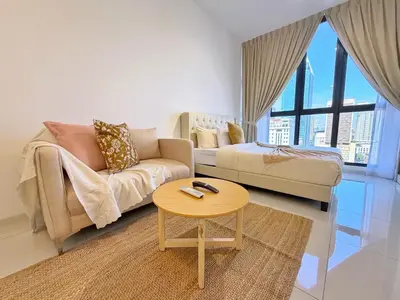 a living room with a couch and a table at Majestic Charming Studio Suite with Infinity Pool in Kuala Lumpur