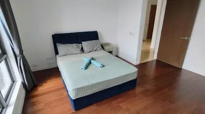 a bed with a blue teddy bear sitting on it at Pomelo Meet Kuala Lumpur in Kuala Lumpur
