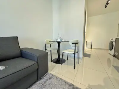 a living room with a couch and a table and chairs at Majestic Modern Studio Suites with Infinity Pool in Kuala Lumpur