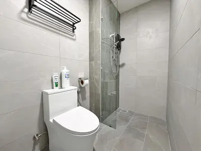 a white bathroom with a toilet and a shower at Majestic Modern Studio Suites with Infinity Pool in Kuala Lumpur