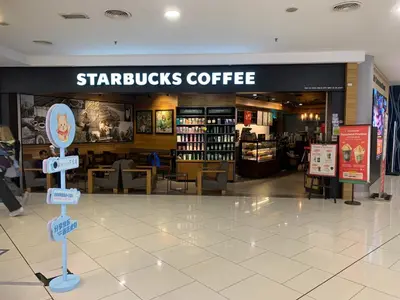 a starbucks coffee shop with a sign in a mall at Premier suites at Quill Residence KL in Kuala Lumpur