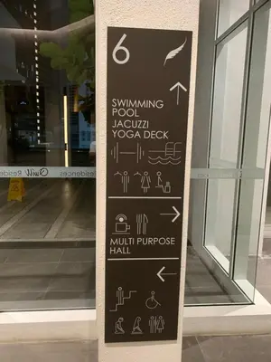 a sign in front of a store door with arrows at Premier suites at Quill Residence KL in Kuala Lumpur