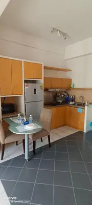 a kitchen with a table and chairs and a refrigerator at Greenstone suites at Seri Bukit Ceylon in Kuala Lumpur