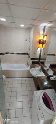 a bathroom with a tub and a sink and a bath tub at Greenstone At Seri Bukit Ceylon klcc in Kuala Lumpur
