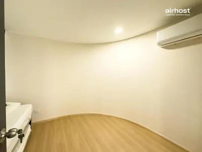 a bathroom with a wooden floor and a white wall at Villa Putra Condo PWTC by Airhost in Kuala Lumpur