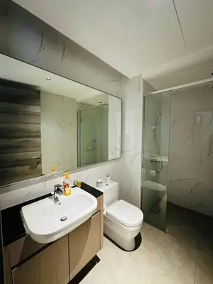 a bathroom with a sink and a toilet and a mirror at Agile Delima Sky View Apartment at TRX Bukit Bintang in Kuala Lumpur