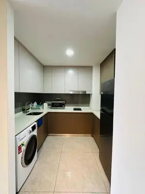 a kitchen with white cabinets and a washer in it at Agile Delima Sky View Apartment at TRX Bukit Bintang in Kuala Lumpur