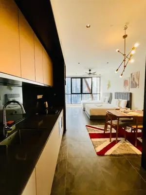a kitchen and living room with a table and a bed at Scarletz Residence KLCC Rooftop Pool in Kuala Lumpur
