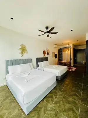 two white beds in a room with a ceiling fan at Scarletz Residence KLCC Rooftop Pool in Kuala Lumpur
