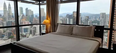 a bed in a room with a large window at Relax Suite Times Square Kl in Kuala Lumpur