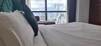 a bedroom with a bed with a view of a city at Relax Suite Times Square Kl in Kuala Lumpur