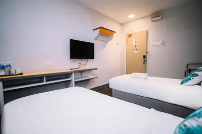 a room with two beds and a desk with a tv at iBilik - Velocity Kuala Lumpur in Kuala Lumpur
