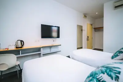 a room with two beds and a tv on a wall at iBilik - Velocity Kuala Lumpur in Kuala Lumpur