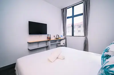 a bedroom with a bed and a desk with a tv at iBilik - Velocity Kuala Lumpur in Kuala Lumpur