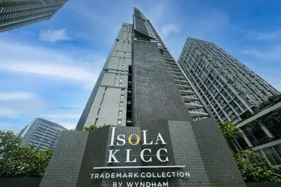 a sign in front of a tall building at Isola KLCC Hotel, Trademark Collection by Wyndham in Kuala Lumpur