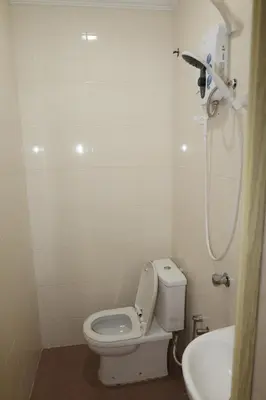 a white bathroom with a toilet and a sink at Haven Hotel Pudu in Kuala Lumpur