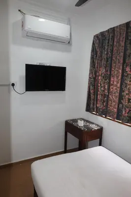 a bedroom with a bed and a tv and a table at Haven Hotel Pudu in Kuala Lumpur