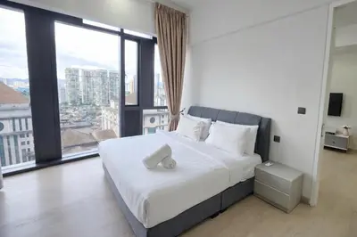 a bedroom with a large bed with a large window at The Global Star Residences At KLCC in Kuala Lumpur