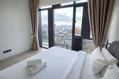 a bedroom with a white bed and a large window at The Global Star Residences At KLCC in Kuala Lumpur