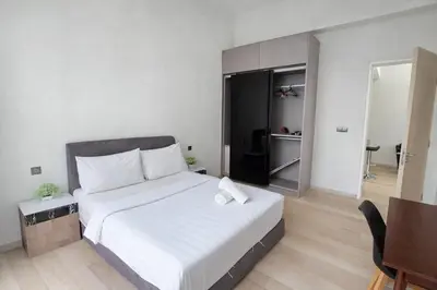 a bedroom with a large white bed and a table at The Global Star Residences At KLCC in Kuala Lumpur