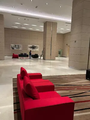 a red couch sitting in a large room at KLCC Marc Residence by Sadz in Kuala Lumpur