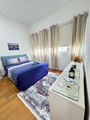 a bedroom with a blue bed and a table at KLCC Marc Residence by Sadz in Kuala Lumpur