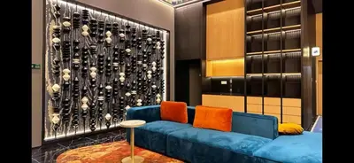 a living room with a blue couch with orange pillows at Kampung Marsa at Majestic Residence, Kuala Lumpur in Kuala Lumpur