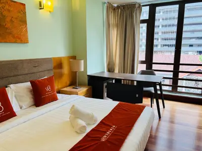a hotel room with a bed with a desk and a window at 183 Ampang KLCC by Widebed in Kuala Lumpur