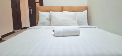 a white bed with a rolled up towel on it at B Service apartment times Square kl in Kuala Lumpur