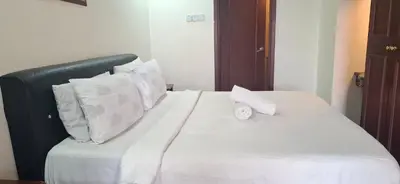 a bed with white sheets and pillows on it at B Service apartment times Square kl in Kuala Lumpur