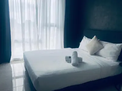 a white bed with towels on it with a window at Axon Residence Glaxay Suite Bukit Bintang KL in Kuala Lumpur