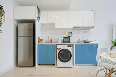 a kitchen with blue cabinets and a washing machine at Continew Residensi City Comfort Stay Cozy 1BR 1BA in Kuala Lumpur
