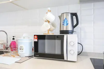a microwave sitting on top of a kitchen counter at Continew Residensi City Comfort Stay Cozy 1BR 1BA in Kuala Lumpur