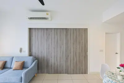 a living room with a blue couch and a sliding door at Continew Residensi City Comfort Stay Cozy 1BR 1BA in Kuala Lumpur