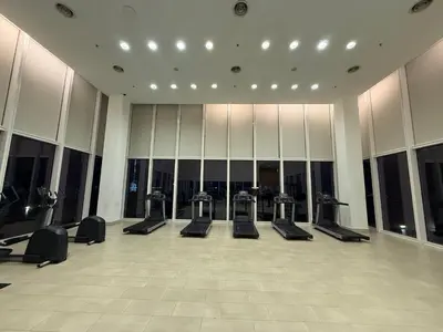 a gym with a row of treadmills and mirrors at Platinum Klcc by PureStay in Kuala Lumpur