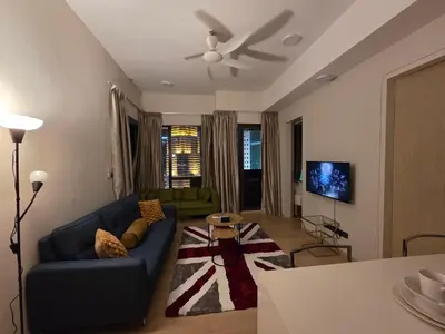 a living room with a blue couch and a tv at KL Star Residance KLCC by Nexus 111 in Kuala Lumpur
