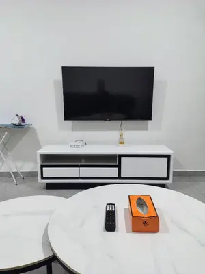 a living room with a tv on a white entertainment center at Agile Bukit Bintang TRX by AR in Kuala Lumpur