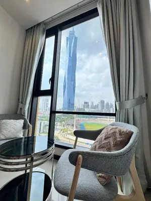 a room with a glass table and a chair and a window at Opus Residences KL by PILLOWTALKS in Kuala Lumpur