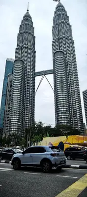 a car parked in a parking lot in front of tall buildings at summer suite, KLCC in Kuala Lumpur