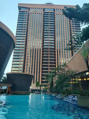 a swimming pool in front of a tall building at Krish Apartment At Times Square in Kuala Lumpur