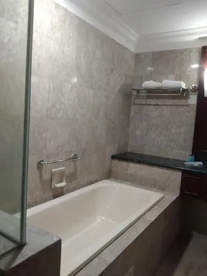 a bathroom with a tub and a glass shower at Krish Apartment At Times Square in Kuala Lumpur