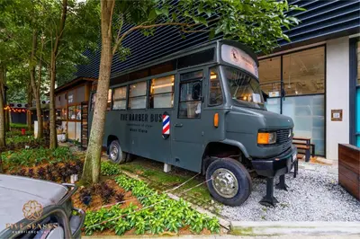 a green bus parked in front of a building at The Ooak Suites Kiara 163 by Five Senses in Kuala Lumpur