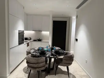 a dining room with a table and chairs in a kitchen at So Sofitel KL Residences in Kuala Lumpur