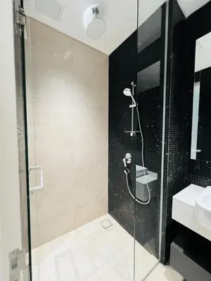 a bathroom with a glass shower with a sink at So Sofitel KL Residences in Kuala Lumpur