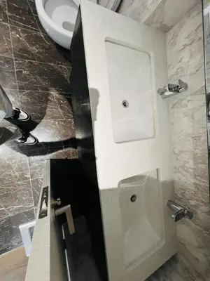a bathroom with a white urinal and a sink at So Sofitel KL Residences in Kuala Lumpur
