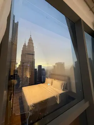 a bedroom with a view of a city skyline at So Sofitel KL Residences in Kuala Lumpur